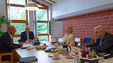 Runde des Fachgesprächs sitzt am Tisch