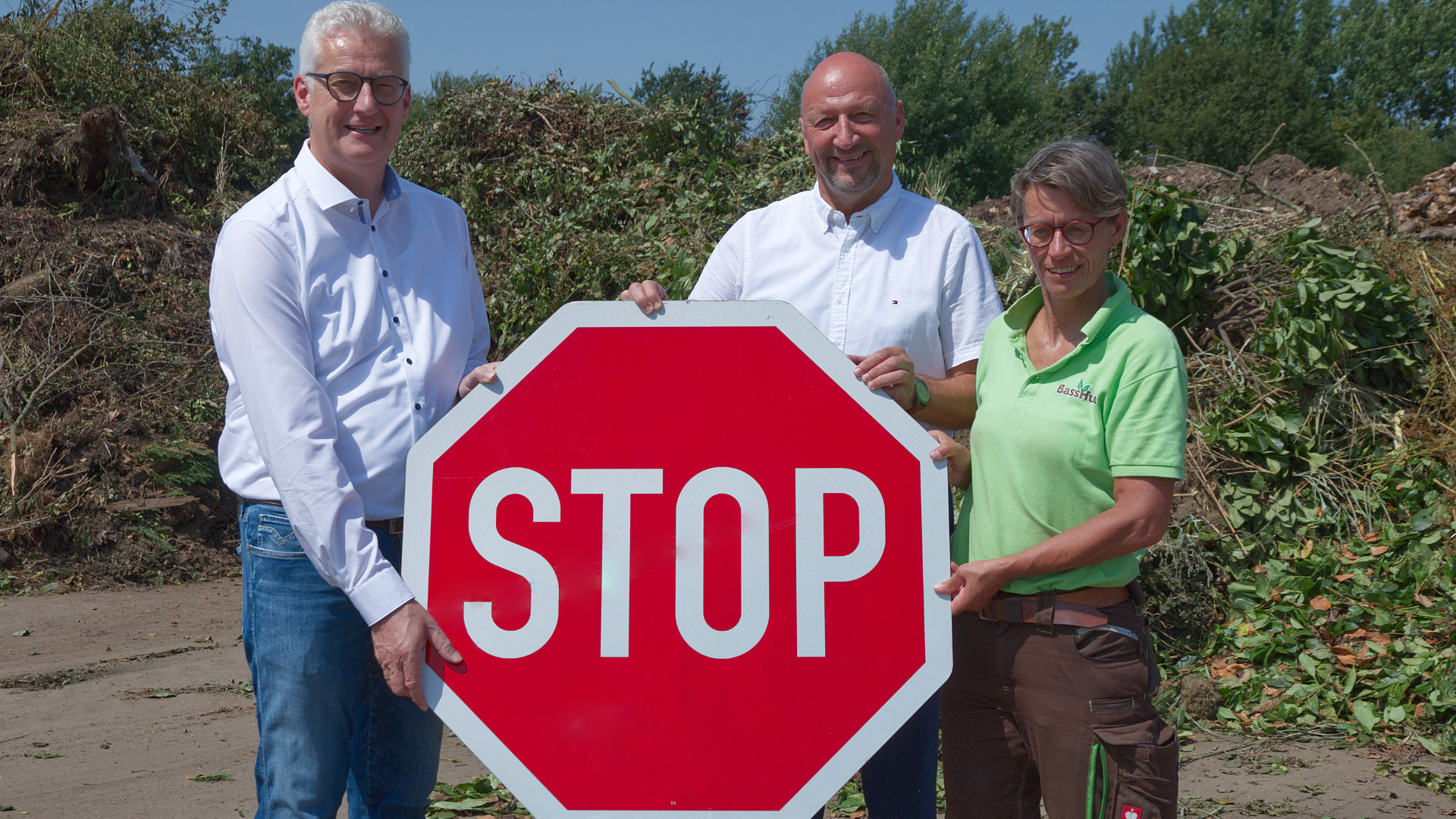 Landrat Cord Bockhop (v. l. n. r.), AWG-Geschäftsführer Andreas Nieweler und AWG-Mitarbeiterin Renate Meyer halten ein Stop-Schild.